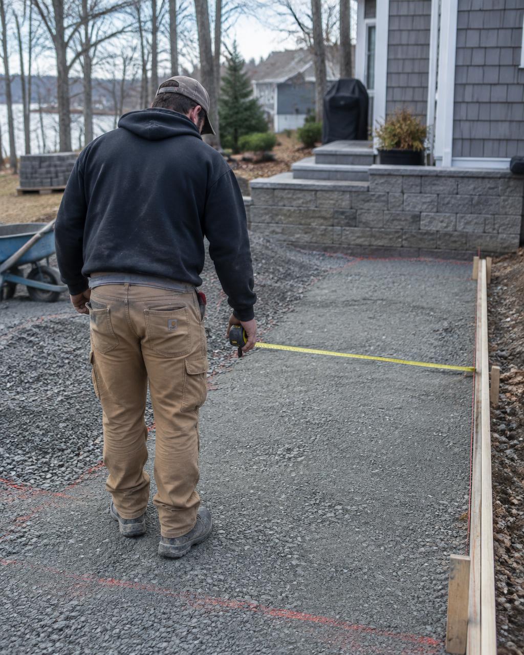 Barreto’s contractor measuring a prepared paver base on a residential job site